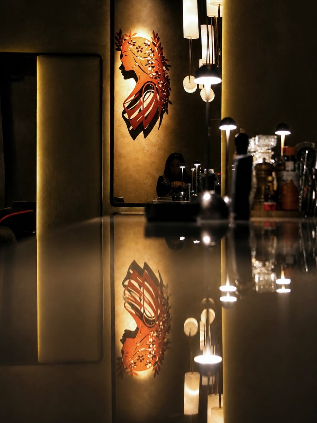 The amber-lit goddess mural above the marble bar counter inside Maia Beirut